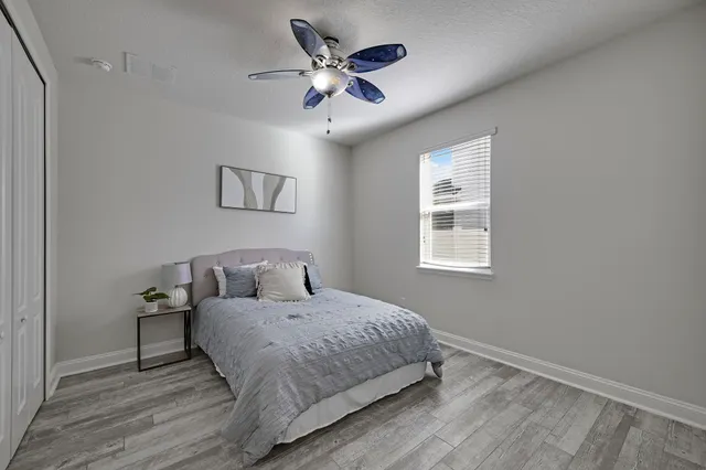 a bedroom with a bed and a ceiling fan