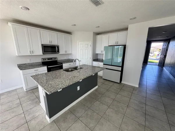 a kitchen with stainless steel appliances granite countertop a stove top oven a sink a counter top space and cabinets