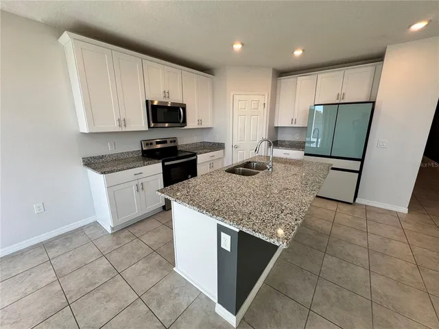 a kitchen with a sink a microwave and refrigerator