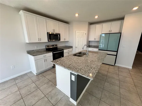 a kitchen with a sink a microwave and refrigerator