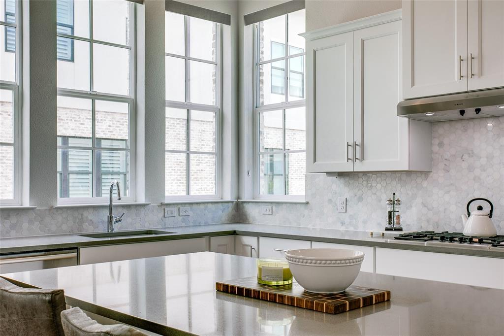 a kitchen with granite countertop a sink and a white wooden cabinets
