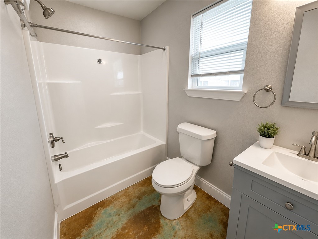 661 West Austin Street, Unit Q Luling, TX 78648 - Photo 7 of 9 a bathroom with a toilet a sink and a bathtub