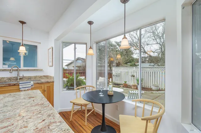 a dining room with furniture a chandelier and wooden floor