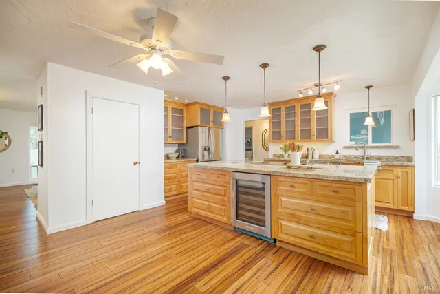 a large kitchen with kitchen island white cabinets and stainless steel appliances
