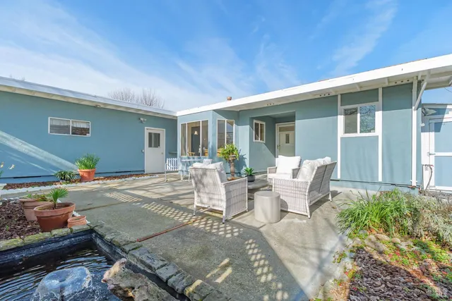 a view of a patio with couches table and chairs and potted plants