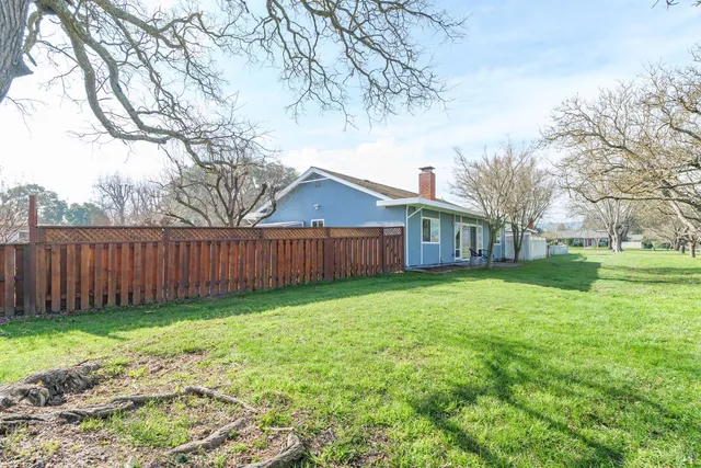 a view of a house with backyard and trees