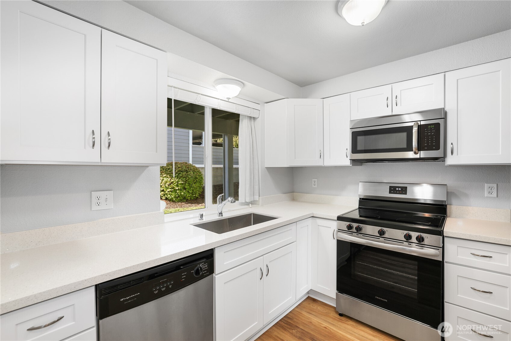 1010 North J Street, Unit 2 Tacoma, WA 98403 - Photo 8 of 29 a kitchen with stainless steel appliances white cabinets and a stove top oven