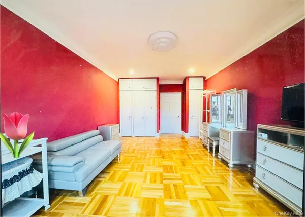 a spacious bedroom with a bed and wooden floor