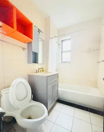 a bathroom with a granite countertop toilet sink and mirror