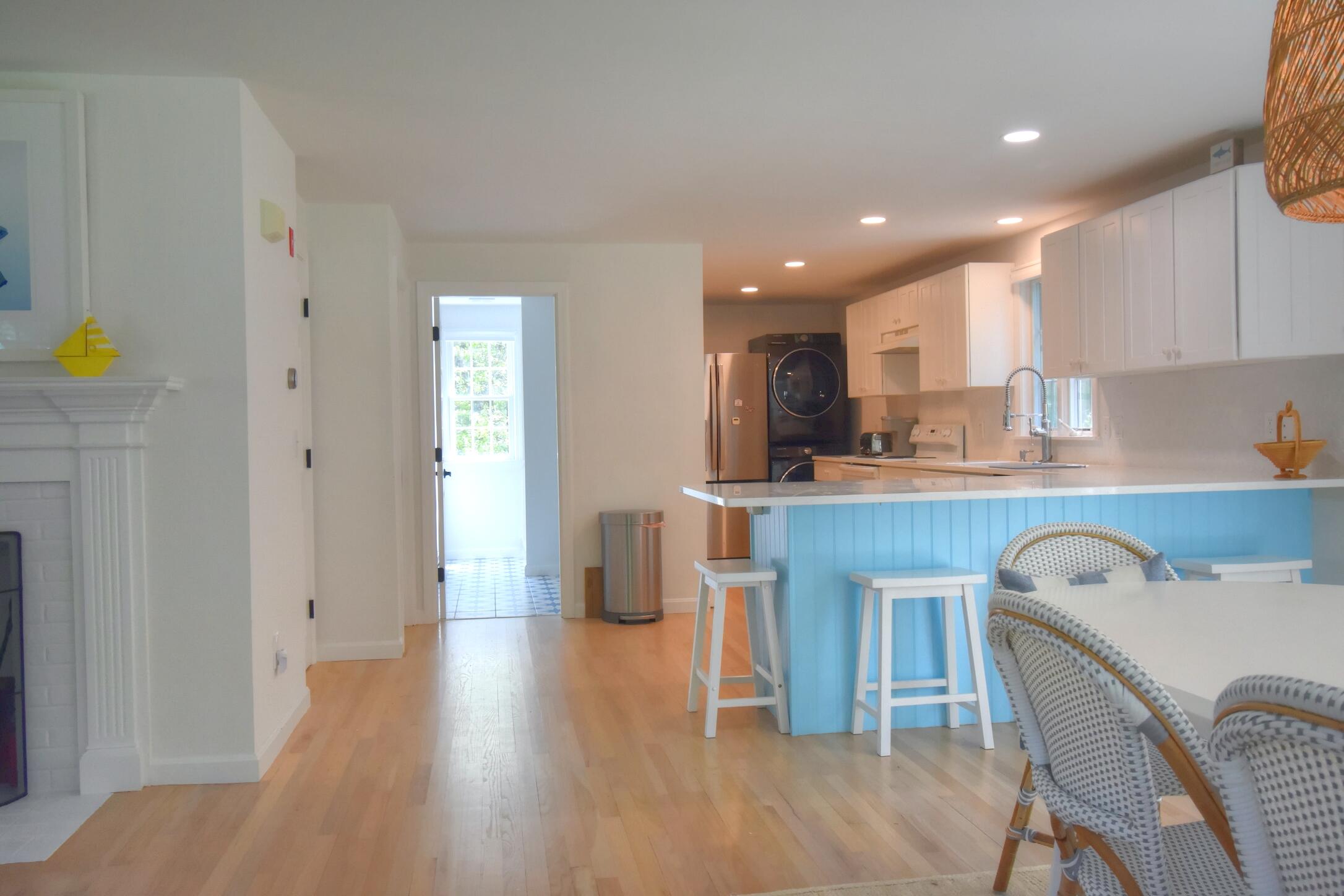 41 Turning Mill Road Brewster, MA 02631 - Photo 9 of 44 a kitchen with kitchen island a dining table chairs and a refrigerator