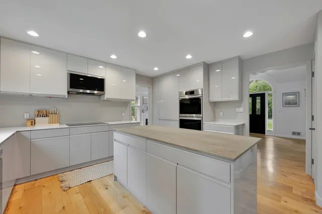 a kitchen with stainless steel appliances granite countertop a sink and a stove top oven