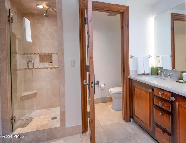a spacious bathroom with a granite countertop sink a toilet and a shower