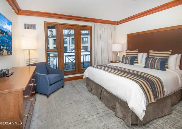 a spacious bedroom with a bed and wooden floor