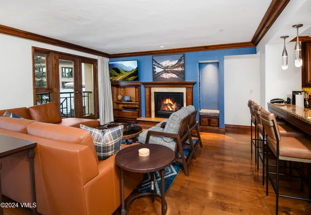 a living room with furniture a fireplace and a floor to ceiling window