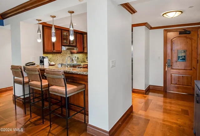 a dining room with stainless steel appliances kitchen island granite countertop a refrigerator and a stove top oven