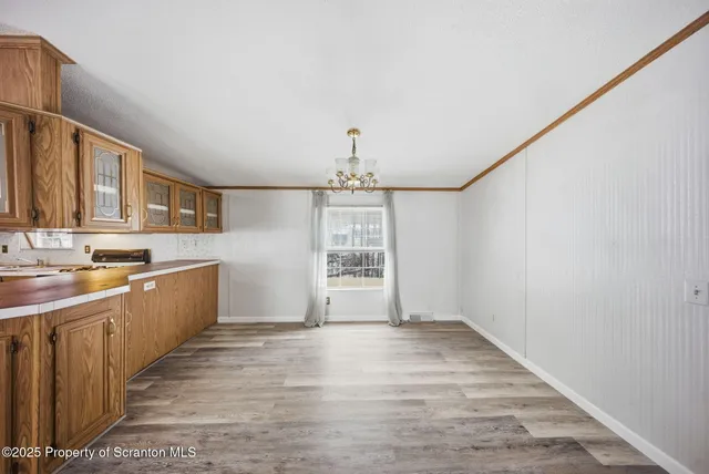a view of a kitchen with a sink and dishwasher with wooden floor