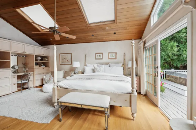 a bedroom with furniture large window and wooden floor