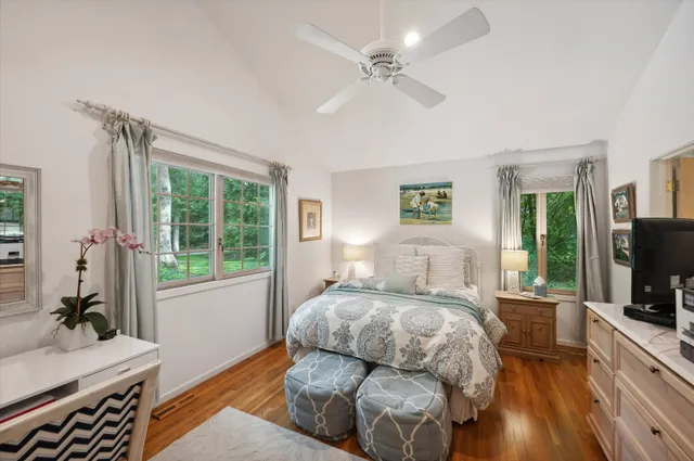 a bedroom with a bed and a flat tv screen on dresser