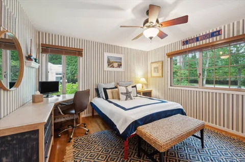 a bedroom with a bed a chandelier and a window