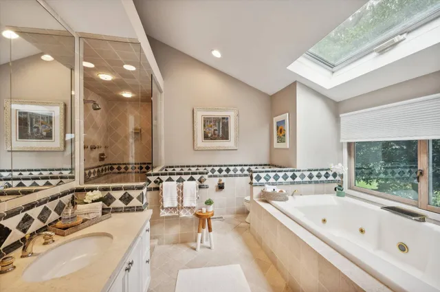 a bathroom with a tub a double vanity sink and mirror