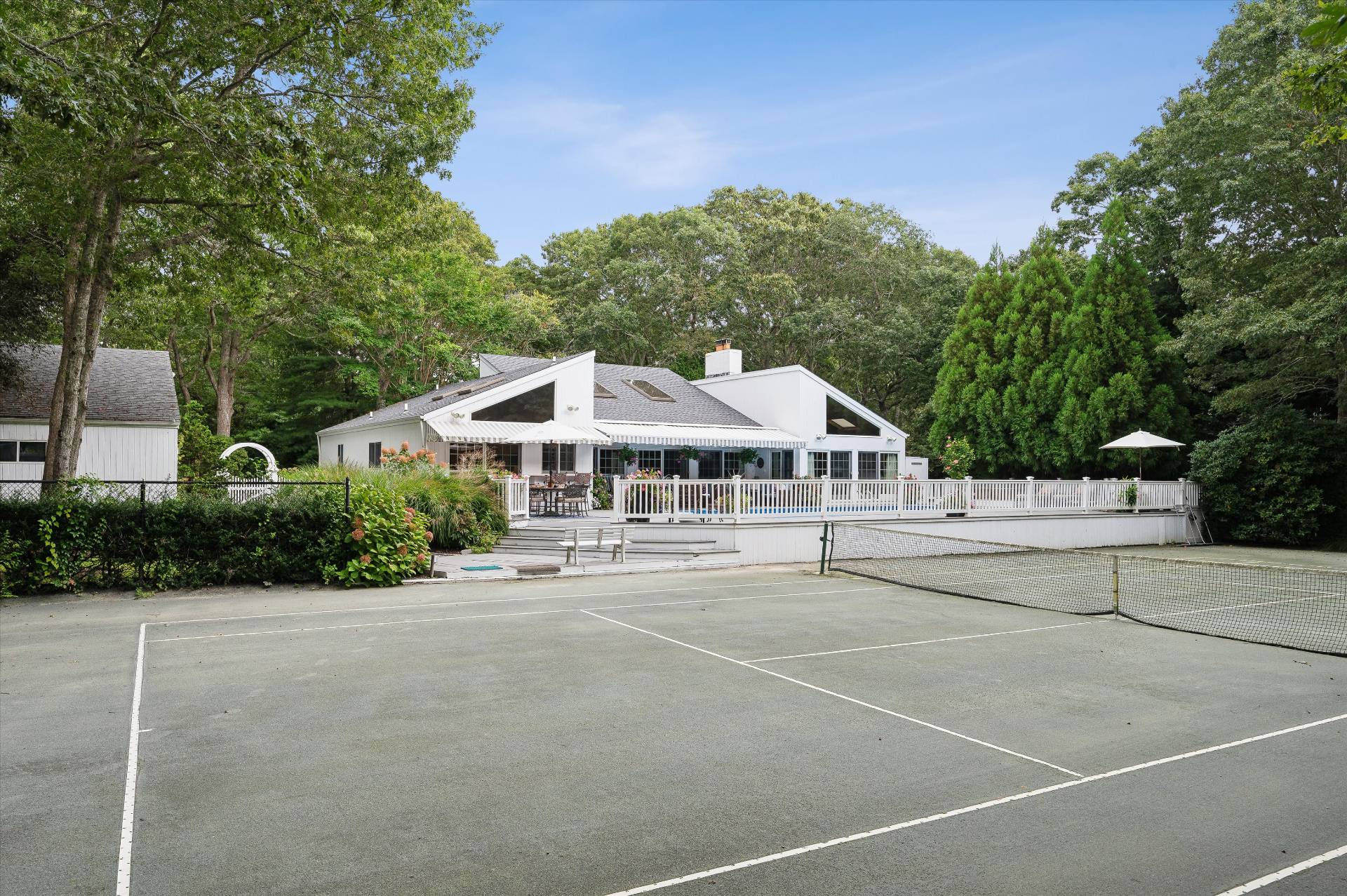 25 Midhampton Avenue Quogue, NY 11959 - Photo 10 of 32 a white building with a bench in front of it
