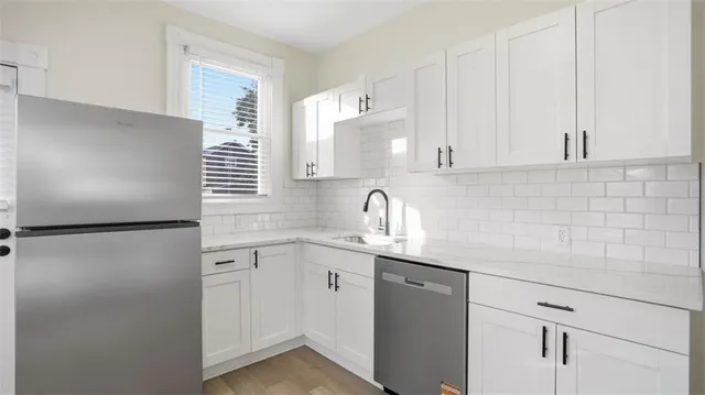 a kitchen with a refrigerator sink and cabinets