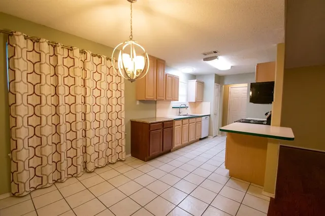 a kitchen with a sink window and cabinets