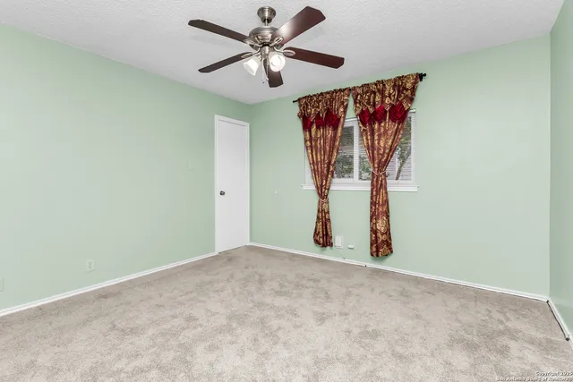 an empty room with a fan and a fan