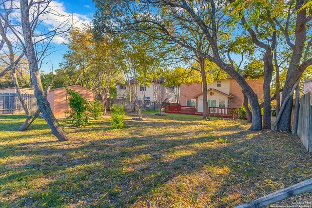 a view of a backyard with wooden fence