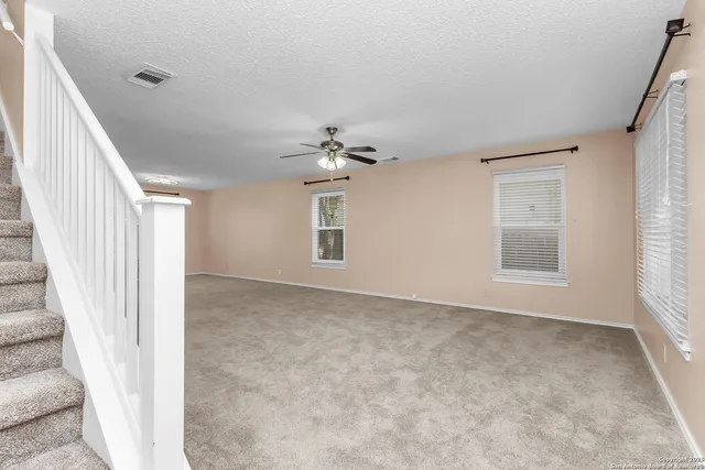 a view of a livingroom with a ceiling fan and window