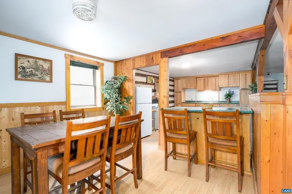 a dining room with stainless steel appliances kitchen island granite countertop a table and chairs