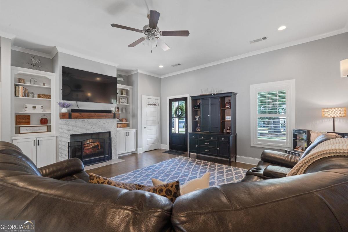 757 Markhams Drive Madison, GA 30650 - Photo 14 of 46 a living room with furniture a flat screen tv and a fireplace