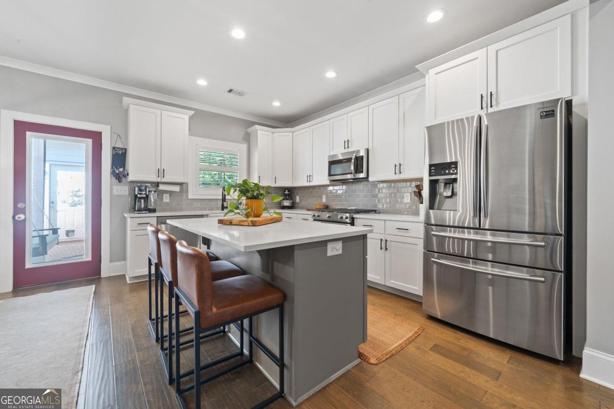 757 Markhams Drive Madison, GA 30650 - Photo 21 of 46 a kitchen with stainless steel appliances a refrigerator stove microwave and cabinets
