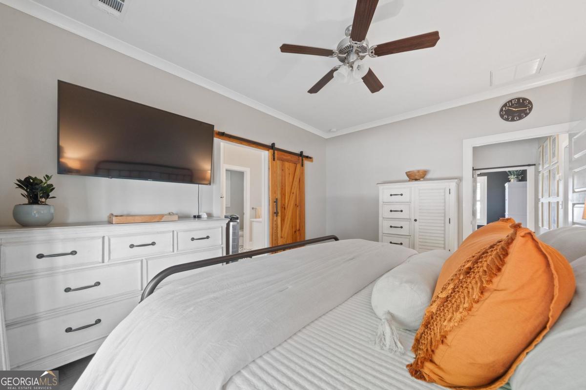 757 Markhams Drive Madison, GA 30650 - Photo 28 of 46 a bedroom with a large bed and a flat tv screen on dresser