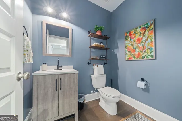a bathroom with a sink mirror vanity and toilet