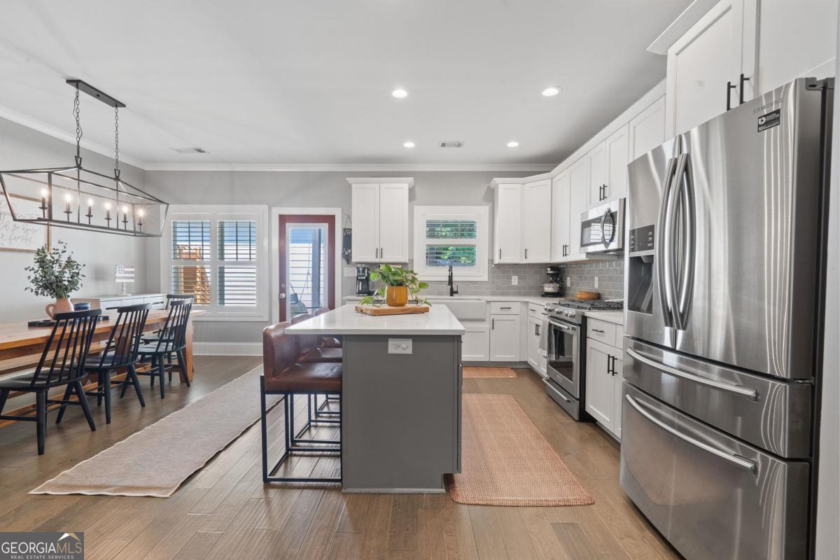 757 Markhams Drive Madison, GA 30650 - Photo 4 of 46 a kitchen with stainless steel appliances granite countertop a refrigerator a stove a sink a dining table and chairs