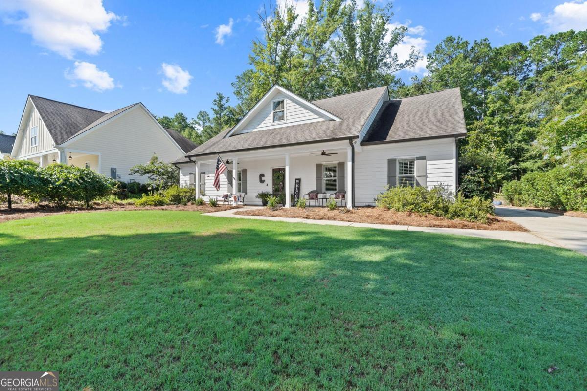 757 Markhams Drive Madison, GA 30650 - Photo 8 of 46 a front view of a house with a yard table and chairs