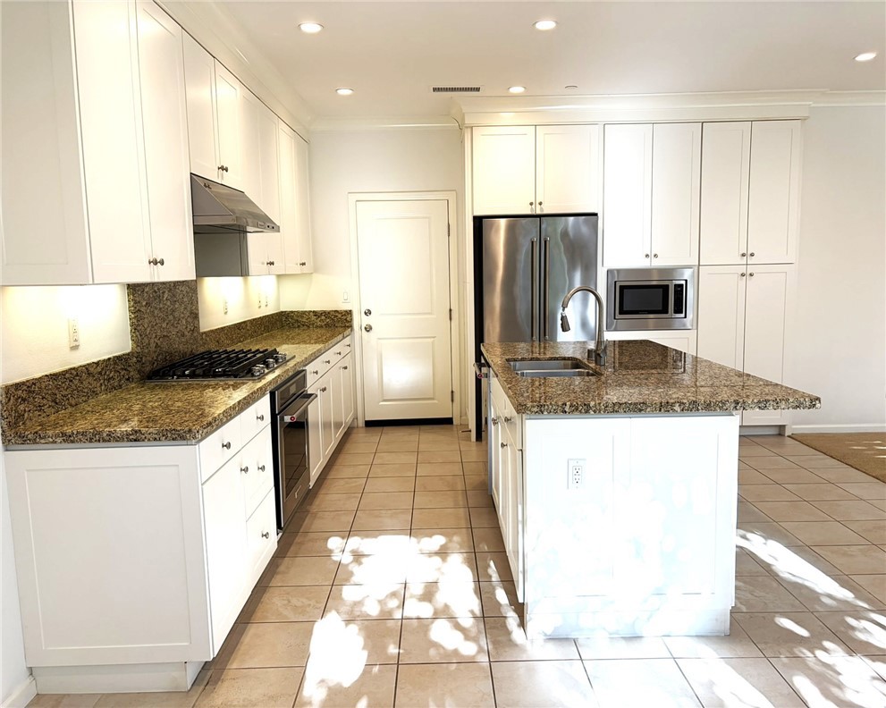 178 Working Ranch Irvine, CA 92602 - Photo 6 of 42 a kitchen with kitchen island granite countertop a stove a sink and a refrigerator