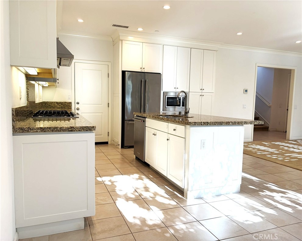178 Working Ranch Irvine, CA 92602 - Photo 8 of 42 a kitchen with stainless steel appliances granite countertop a stove a refrigerator a sink and white cabinets