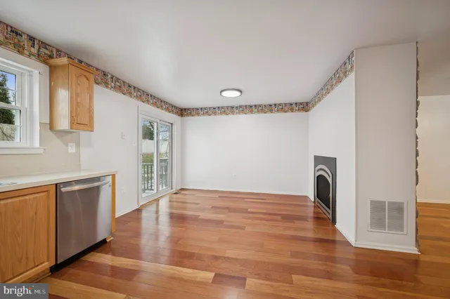 a dining room with wooden floor a chandelier a wooden table and chairs