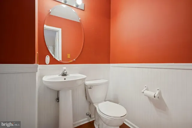 a kitchen with stainless steel appliances a stove top oven a sink a refrigerator white cabinets and wooden floor