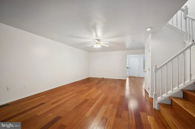 wooden floor in an empty room with a chandelier