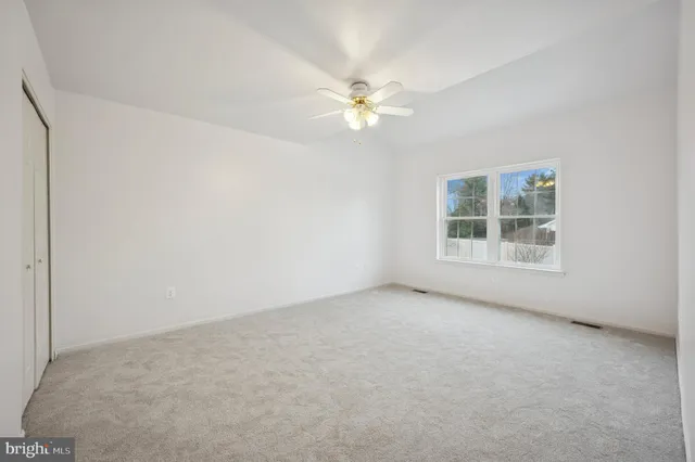 an empty room with fan and entrance