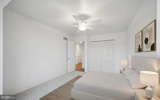 an empty room with a window and a fan