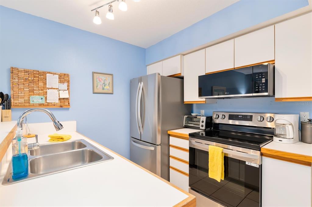 9400 Little Gasparilla, Unit H2 Placida, FL 33946 - Photo 12 of 47 a kitchen that has a microwave and a sink