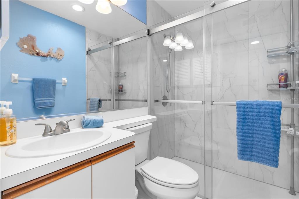 9400 Little Gasparilla, Unit H2 Placida, FL 33946 - Photo 14 of 47 a bathroom with a sink a toilet a mirror and shower