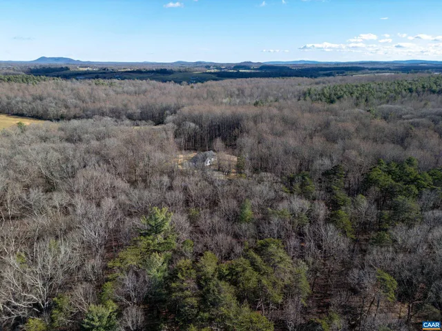 a view of a hallway with wooden floor and a living room
