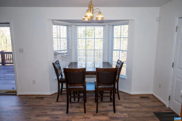 a view of an empty room with wooden floor and a bathroom