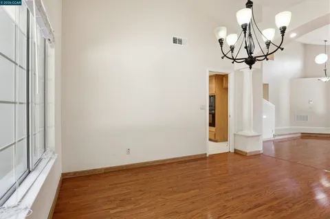 a view of empty room with wooden floor and window