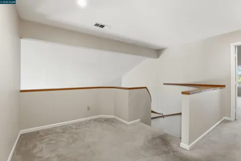 an empty room with windows and fireplace